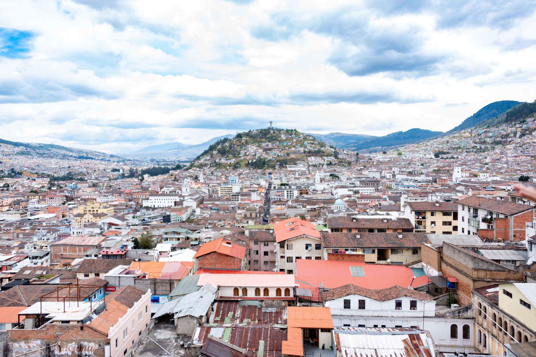 Panoramic view of Quito, Ecuador, with residential buildings and mountains in the background